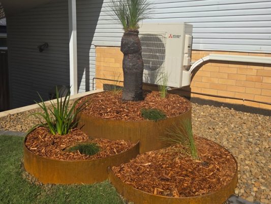 Corten steel garden planter with native grass tree and other native grasses. Landscaping Brisbane northside suburb of Aspley